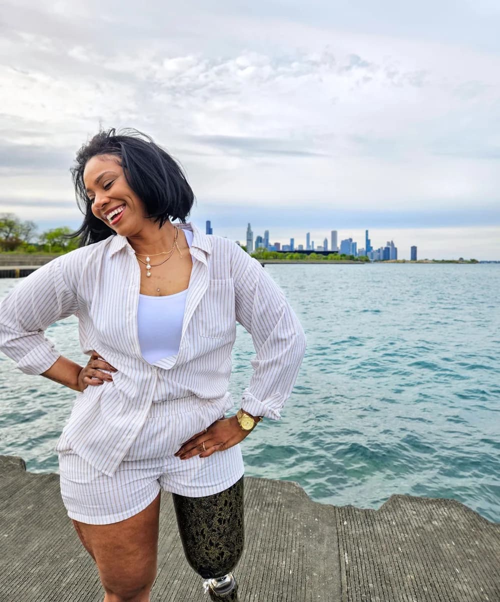 Kalisha smiling beside Lake Michigan with the Chicago skyline behind her